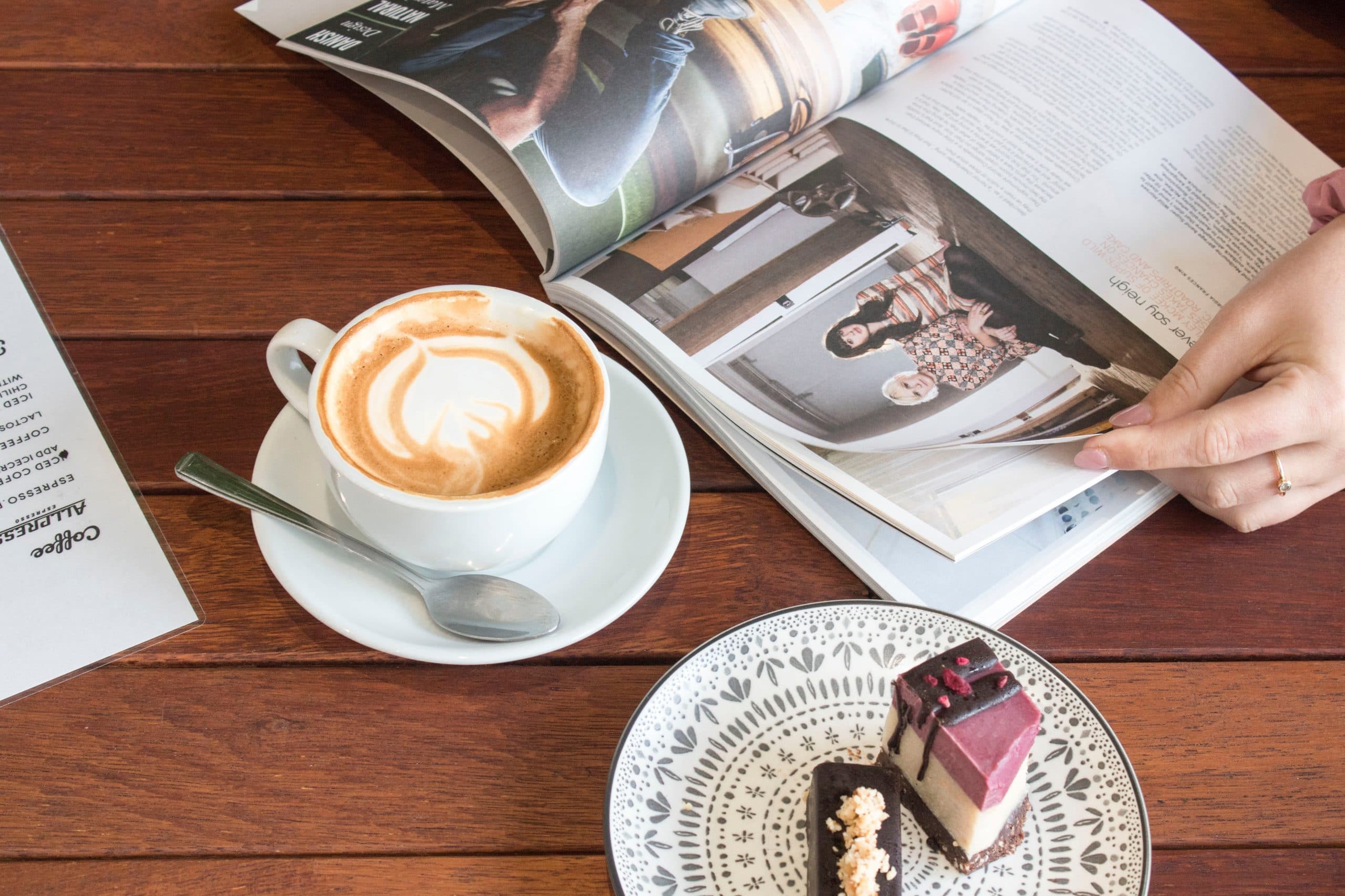 Membaca Buku Majalah di Cafe dengan Kopi (socialcut)